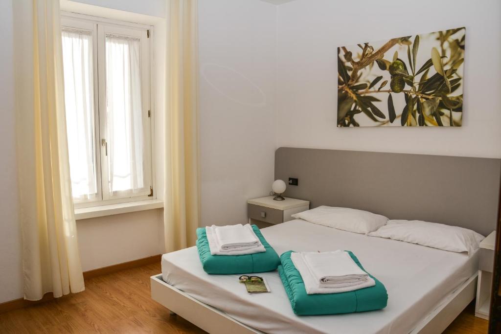 托尔博莱斯特拉运动式公寓的一间卧室配有一张带绿色和白色毛巾的床