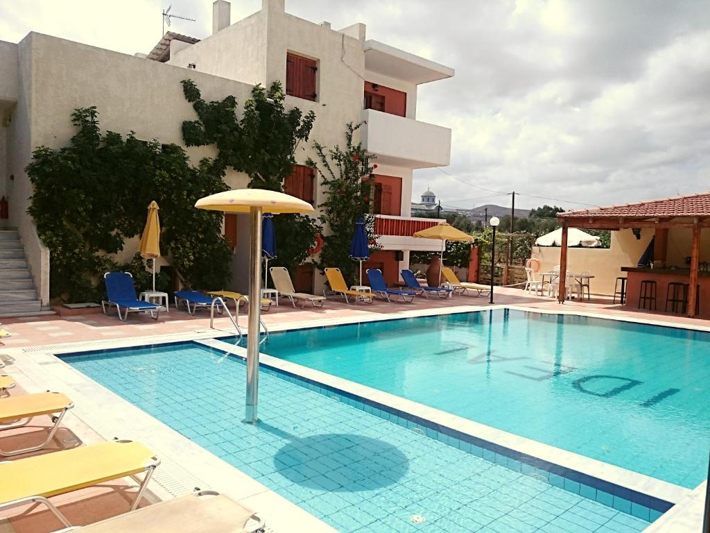 库基尼坎尼奥Ideal Hotel的一座带椅子和遮阳伞的游泳池位于大楼旁