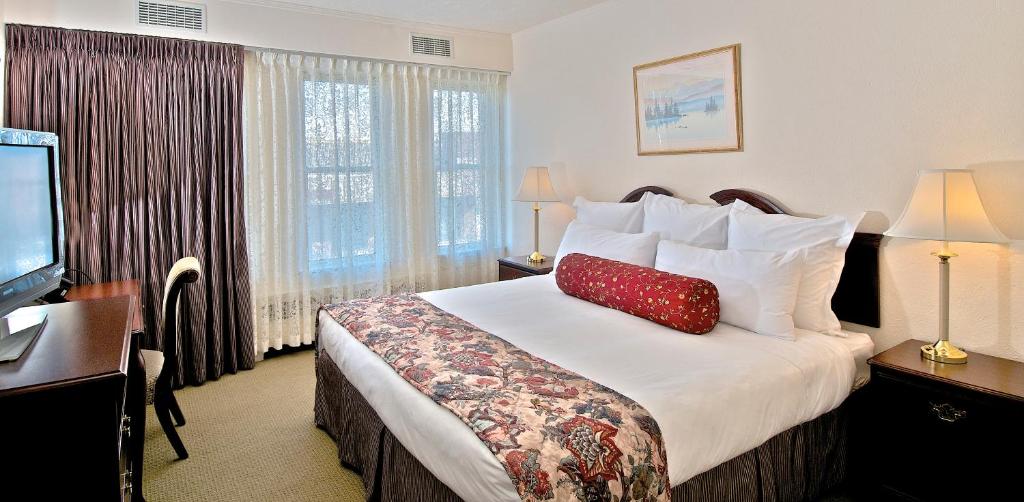安克雷奇安克雷奇历史酒店的酒店客房,配有一张红色枕头的床