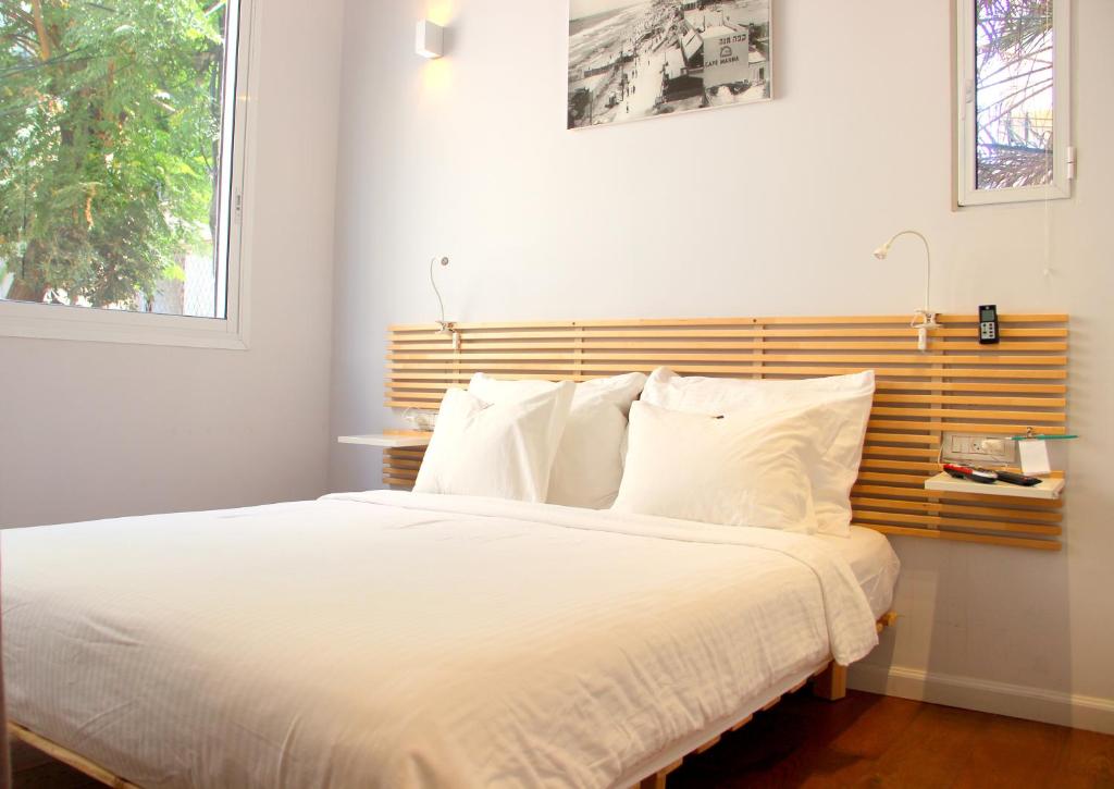 特拉维夫1000Nights B St的卧室配有白色的床和木制床头板
