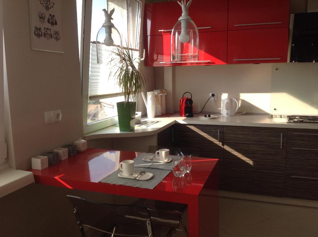 罗兹AS Apartment Lodz的一间厨房,配有红色橱柜和红色桌子