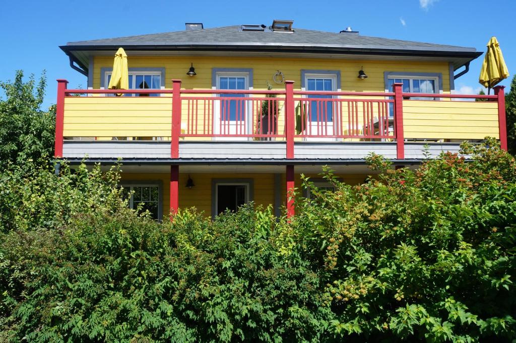 德鲁斯基宁凯Guest House Mr Fox的一座大型黄色房子,树顶上设有甲板