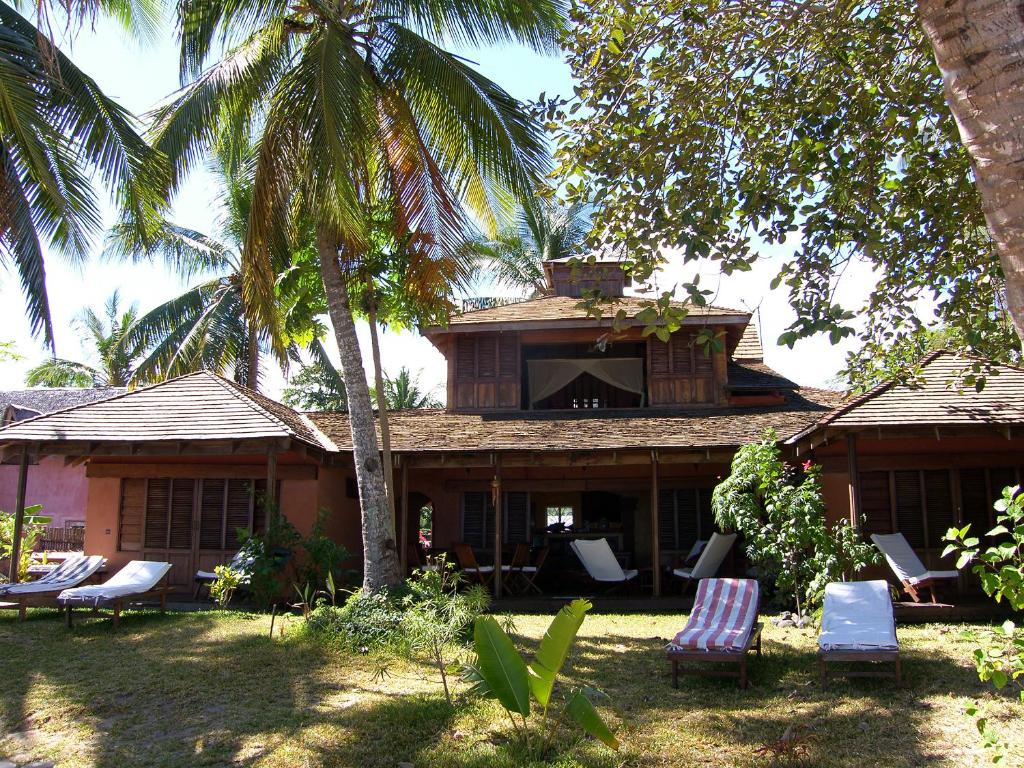 阿姆巴托洛阿卡Residence Tsara Vintana的一座房子,里面摆放着一束椅子和棕榈树
