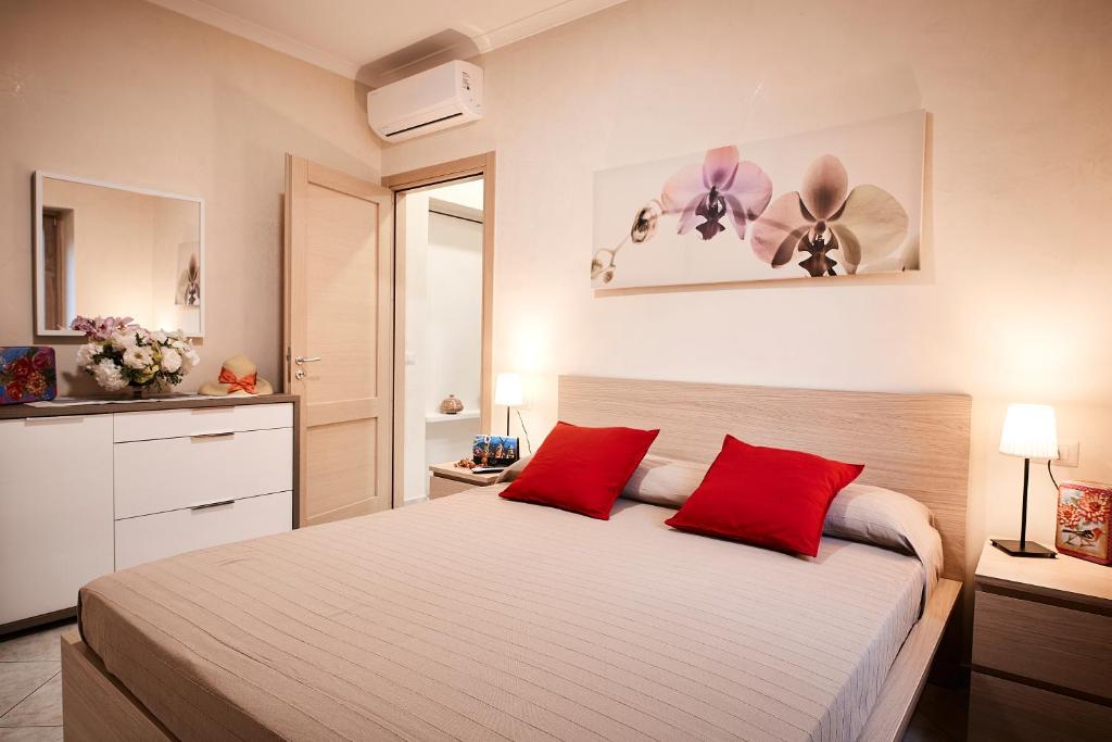 拉维罗Casa Vacanze La Trinità的一间卧室配有一张带红色枕头的大床