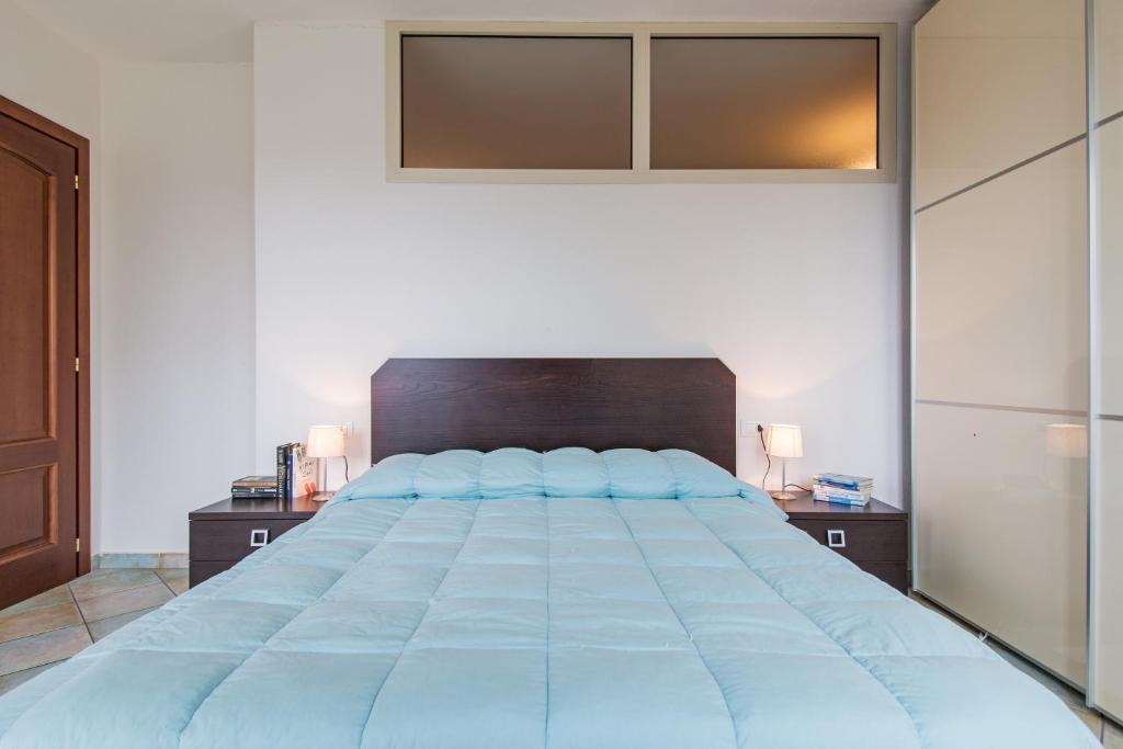 奥罗塞伊Residenza Maria Antonia - Private Apartment的一间卧室配有一张带蓝色枕头的大床