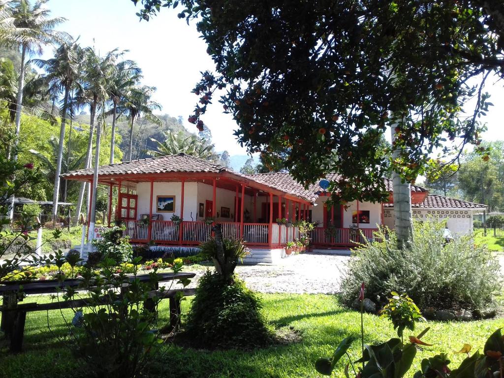 萨兰托Hostal Rio Arabia - Valle De Cocora HOTEL的前面有花园的红色房子