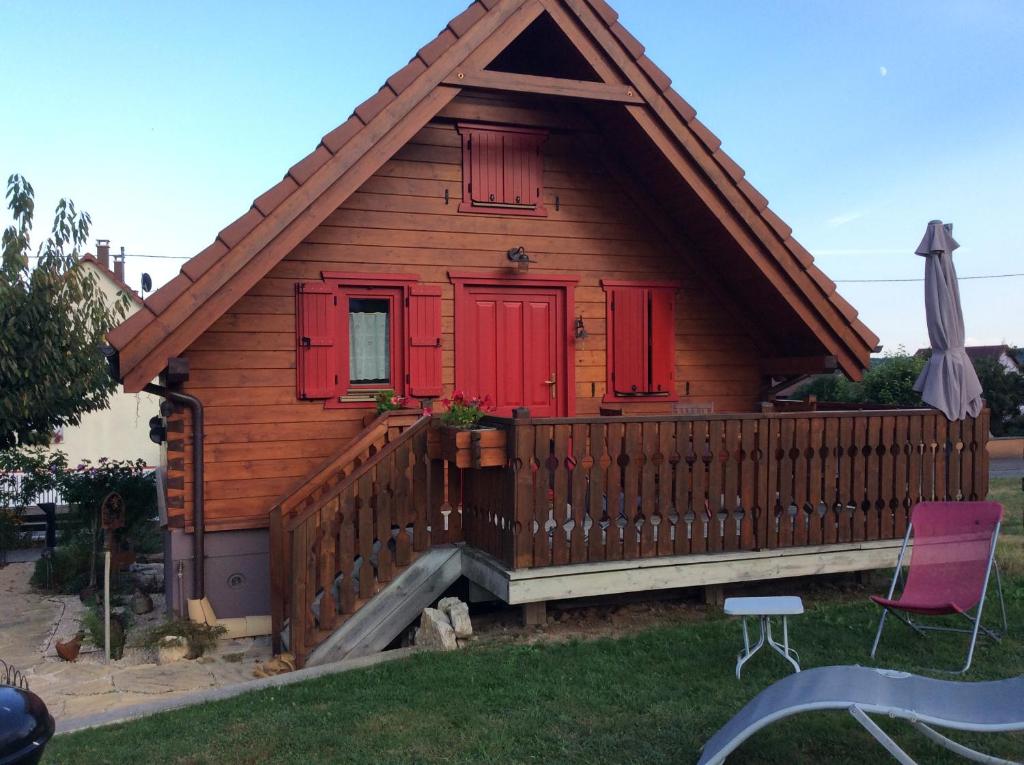 万泽费勒当Chalet Colline et Lou的一间设有红色门和木甲板的小房子