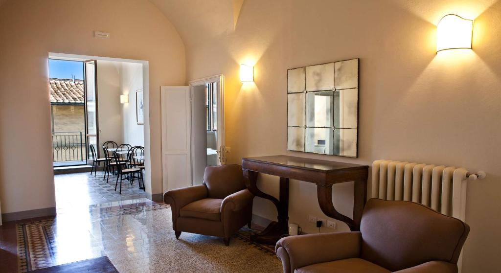 佛罗伦萨德罗梅达里奥I1住宿加早餐旅馆的客厅配有椅子、书桌和桌子