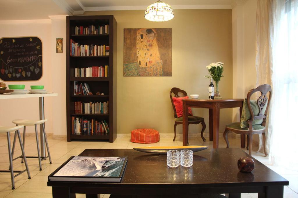 大加那利岛拉斯帕尔马斯Tiffany's Apartment的客厅配有桌椅和书架