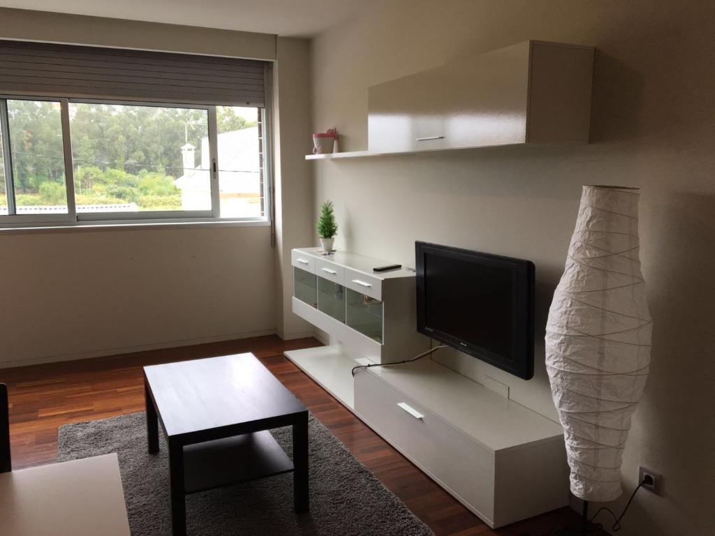 艾利亚德亚罗萨Apartamento Alvaro的客厅配有平面电视和桌子。