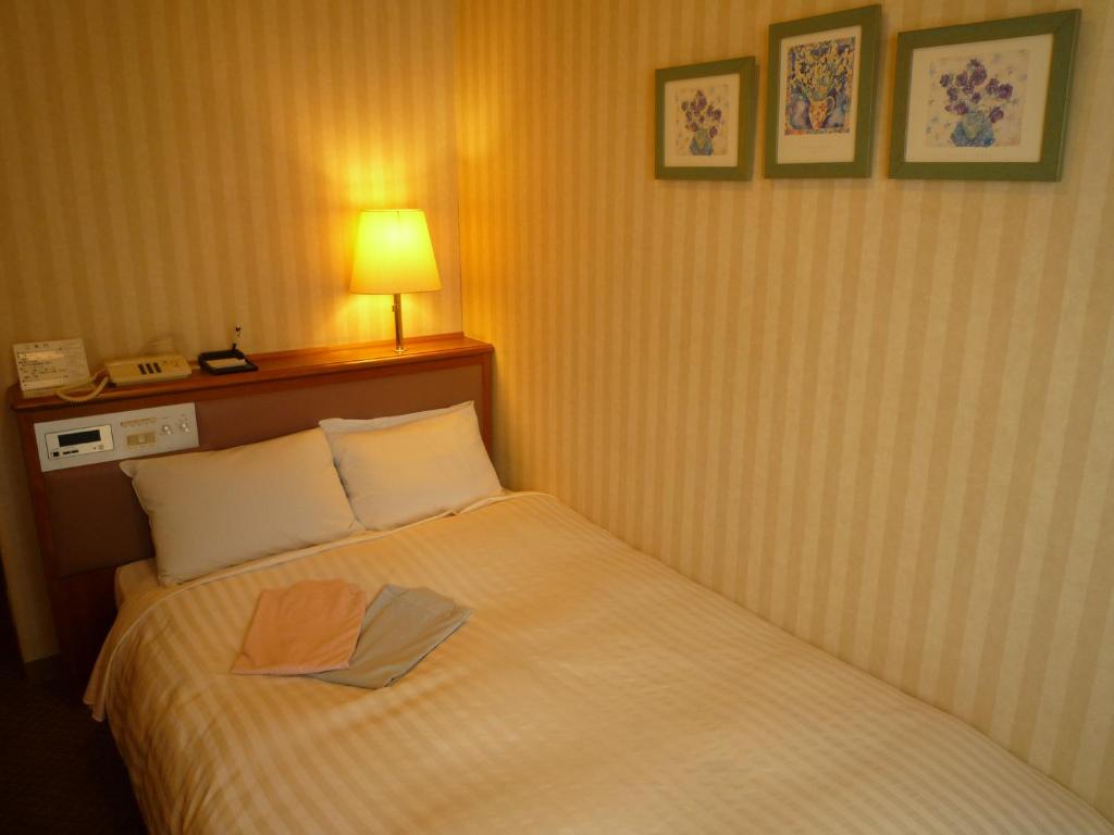 郡山郡山皇冠山酒店的一间酒店客房,配有一张带毛巾的床