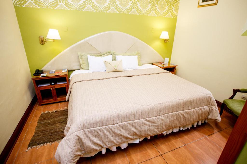 利马利马瓦瑞精品酒店的一间卧室配有一张带白色床头板的大床