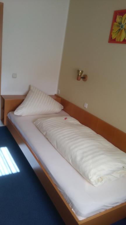 克罗伊茨塔尔Landgasthof & Hotel "Merje"的白色床单间的一张床