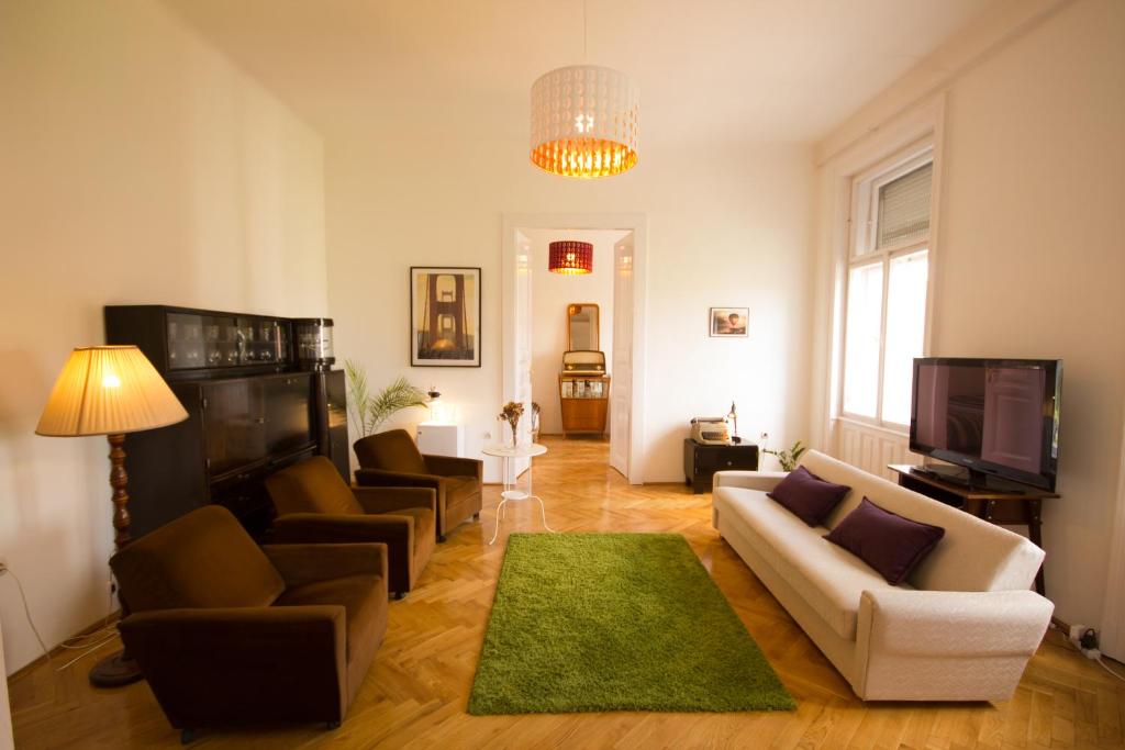 布达佩斯体育馆公寓的客厅配有沙发、椅子和电视