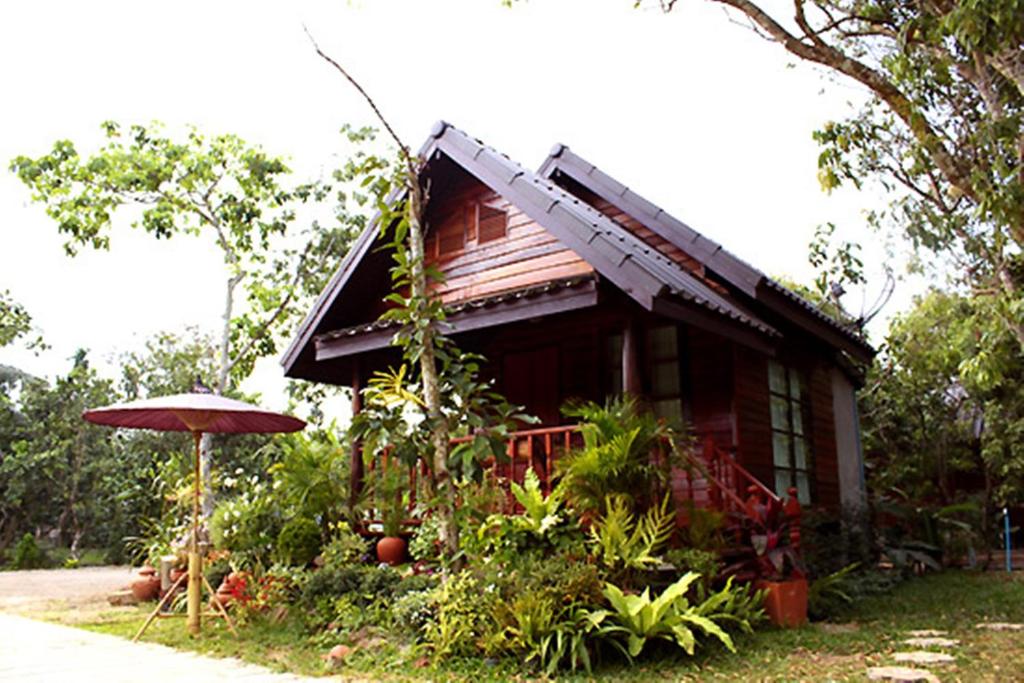 安帕瓦Baansuan Lychee Maeklong Resort Ampawa的前面有一把伞的小房子