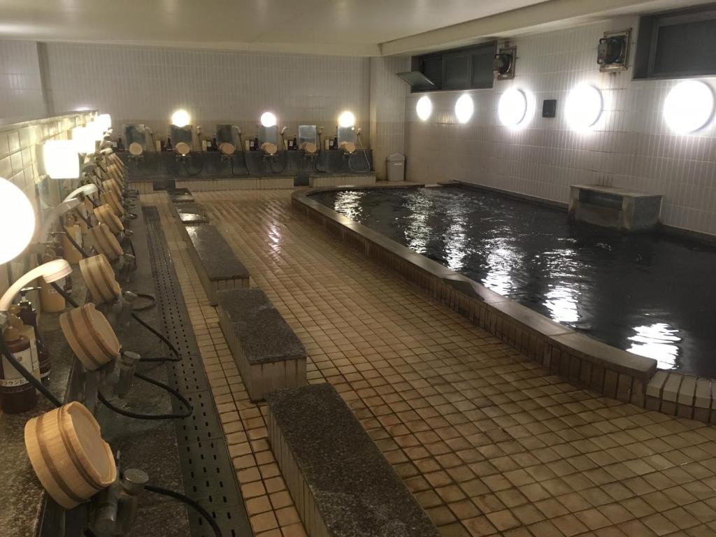 大分皇冠山大分酒店的一个带椅子的浴室内的大型游泳池