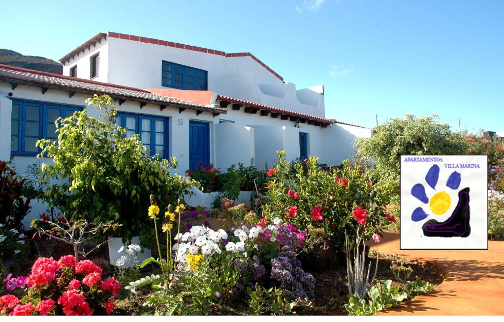 拉卡莱塔Apartamentos y Habitaciones Villa Marina的一座花园,在一座建筑前种有鲜花