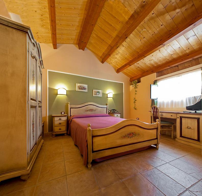 莱西纳B&B Liu' Palazzo Ducale的一间卧室配有一张床、一张书桌和一个窗户。