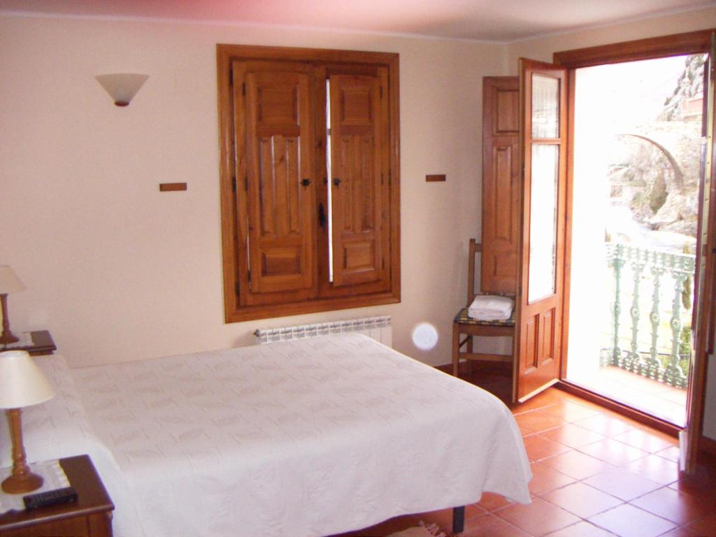 阿尔内迪略Casa Rural Peñalba的卧室设有白色的床和大窗户