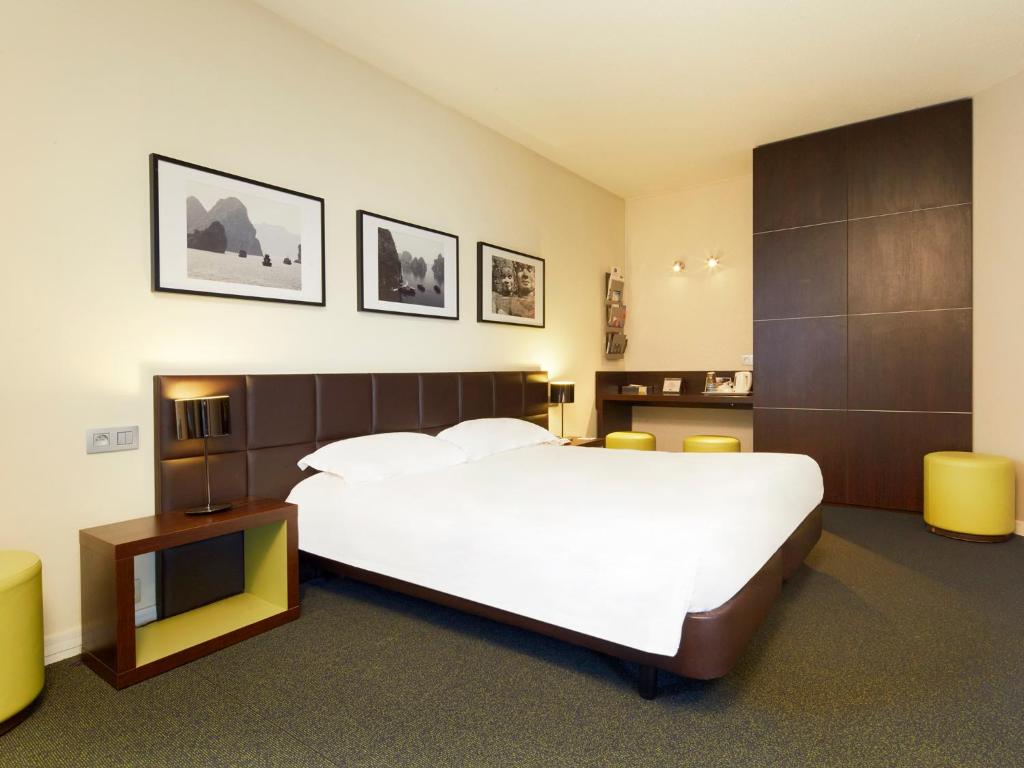 阿蒂斯蒙斯基里亚德奥利机场安蒂蒙酒店的卧室配有一张白色的大床和一张桌子