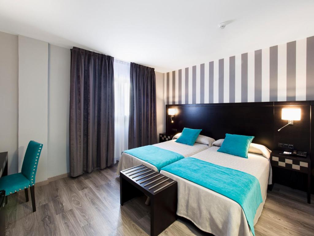 巴利亚多利德中央公园酒店的酒店客房配有一张带蓝色枕头的大床