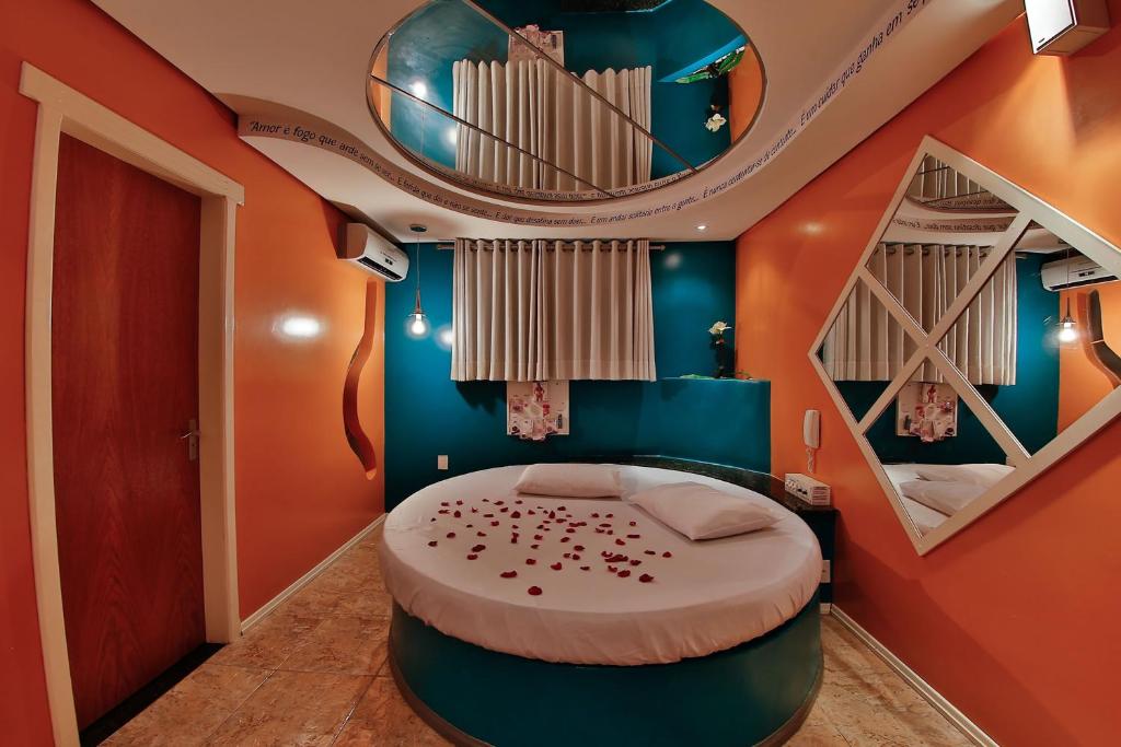 上克鲁斯帕拉迪索情趣酒店 - 克鲁斯阿尔塔的一间设有圆床的卧室,位于一间拥有蓝色和橙色墙壁的房间