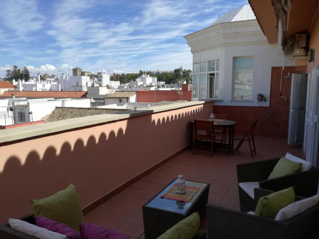 桑卢卡尔-德巴拉梅达Atico Infanta Eulalia的阳台配有沙发和屋顶桌子。