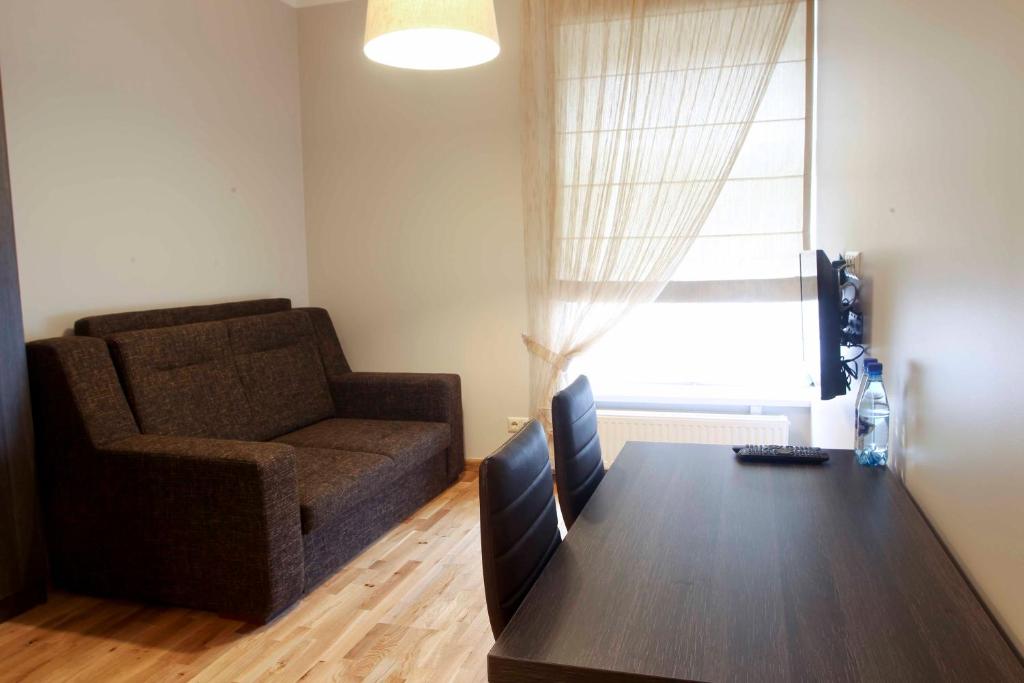 采西斯Mēness Apartamenti的客厅配有沙发和带电脑的桌子