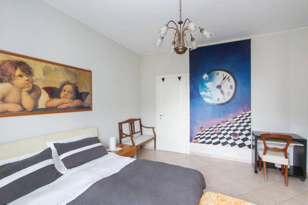米兰安琪莉卡度假屋的卧室配有一张床,墙上挂着一个钟