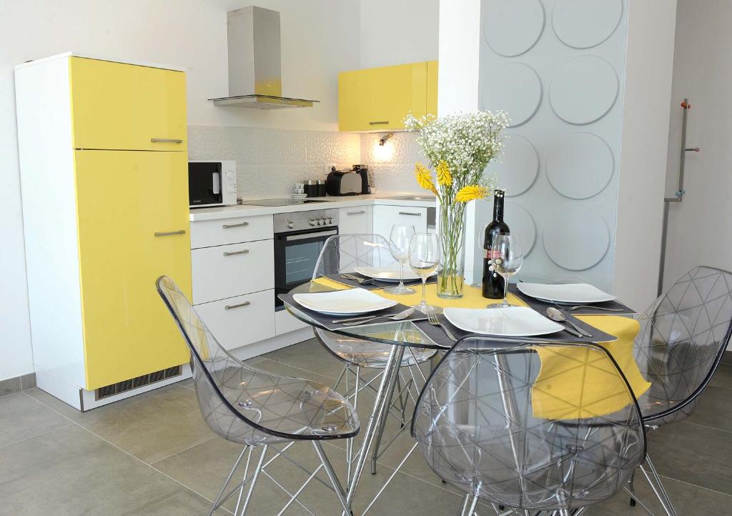 里耶卡Apartment Livingstone的厨房配有桌椅和黄色冰箱。