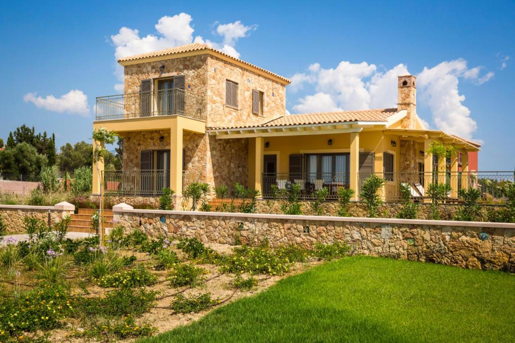 斯沃伦塔Orion Luxury Villa的一座石墙和绿色草地的房子