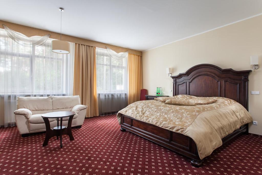 德鲁斯基宁凯梅诺莉美兰公寓酒店的一间卧室配有一张床、一张沙发和一把椅子