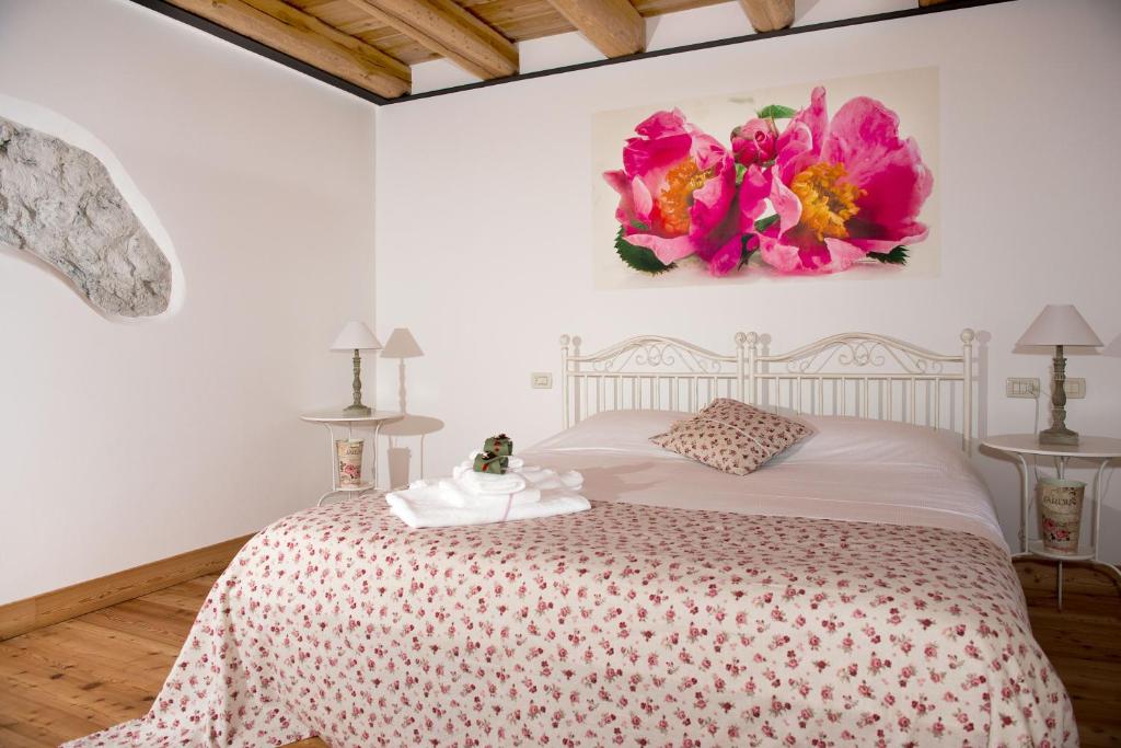 Forni di Sotto多洛米蒂大酒店 的卧室配有一张墙壁上粉红色鲜花的床。