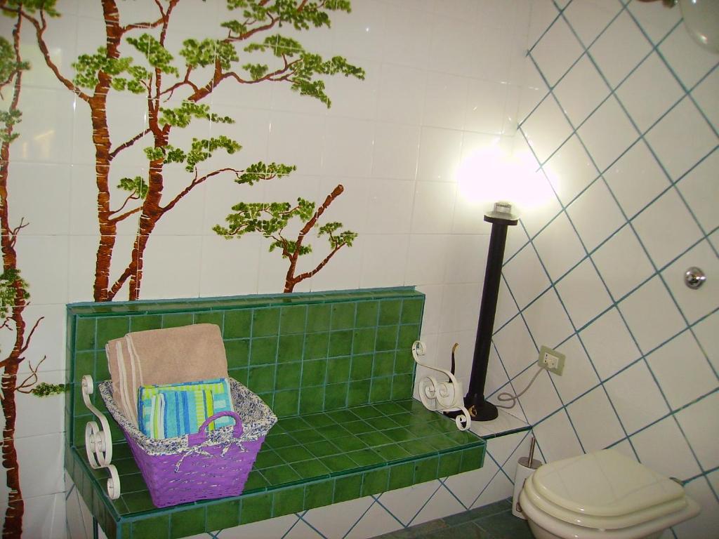 UsiniL'Antica Cantina的绿色瓷砖浴室设有卫生间和树木