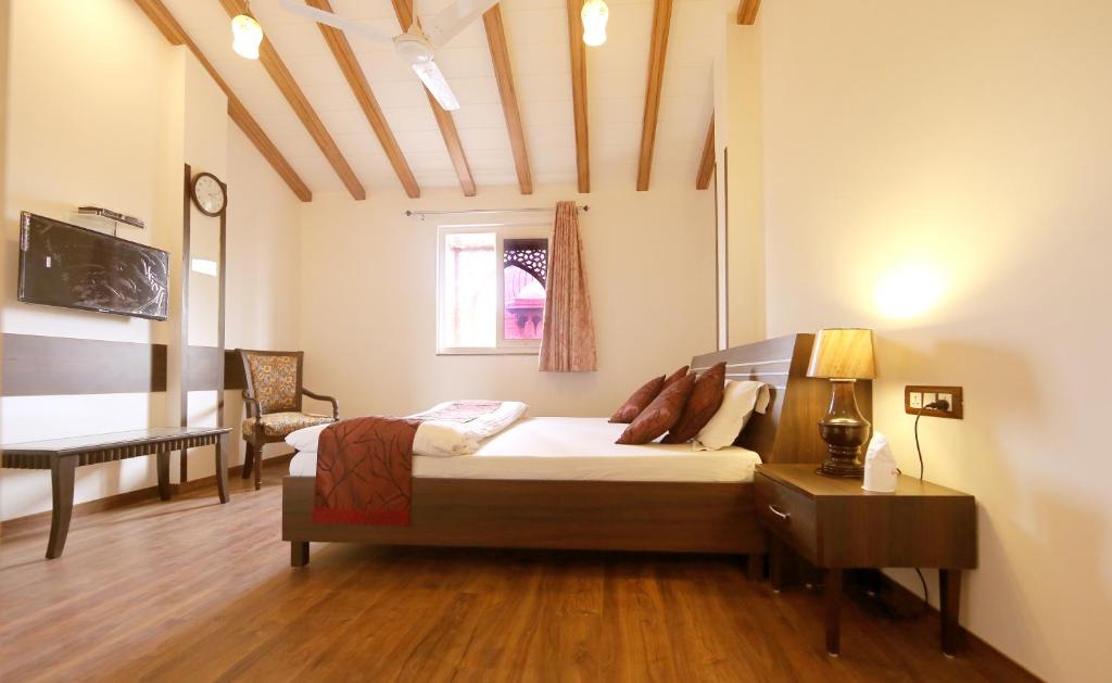 新德里爱玩夏希酒店 的一间卧室配有一张床和一张书桌