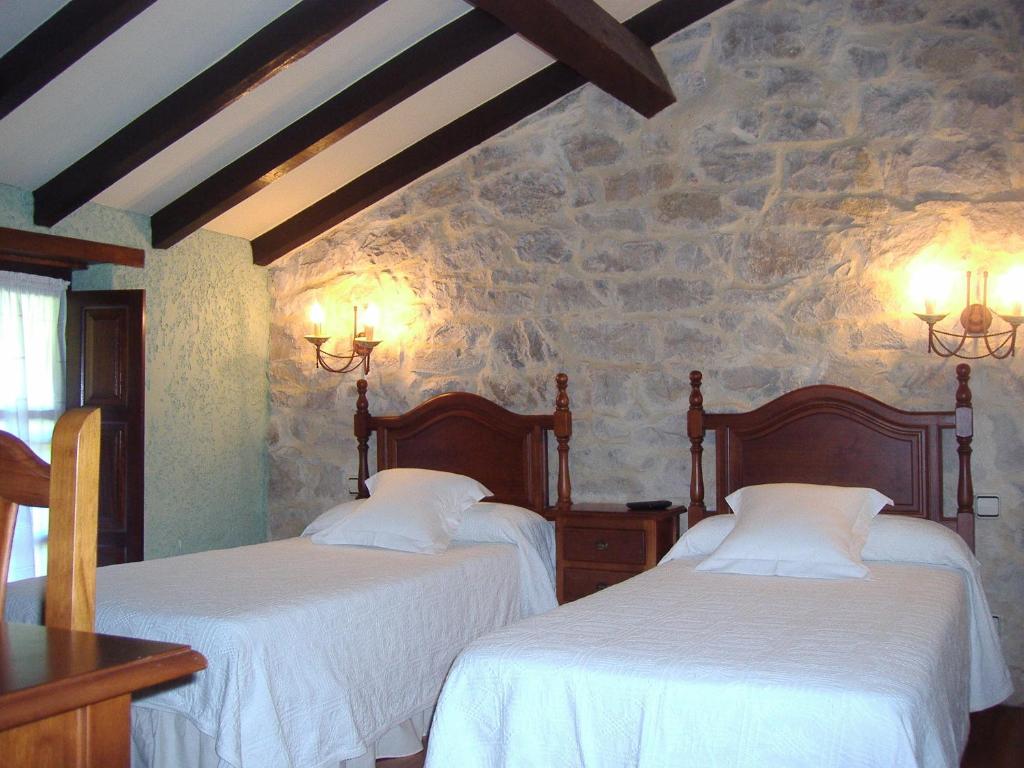 Barcenilla拉斯佩特斯旅馆的石墙客房的两张床