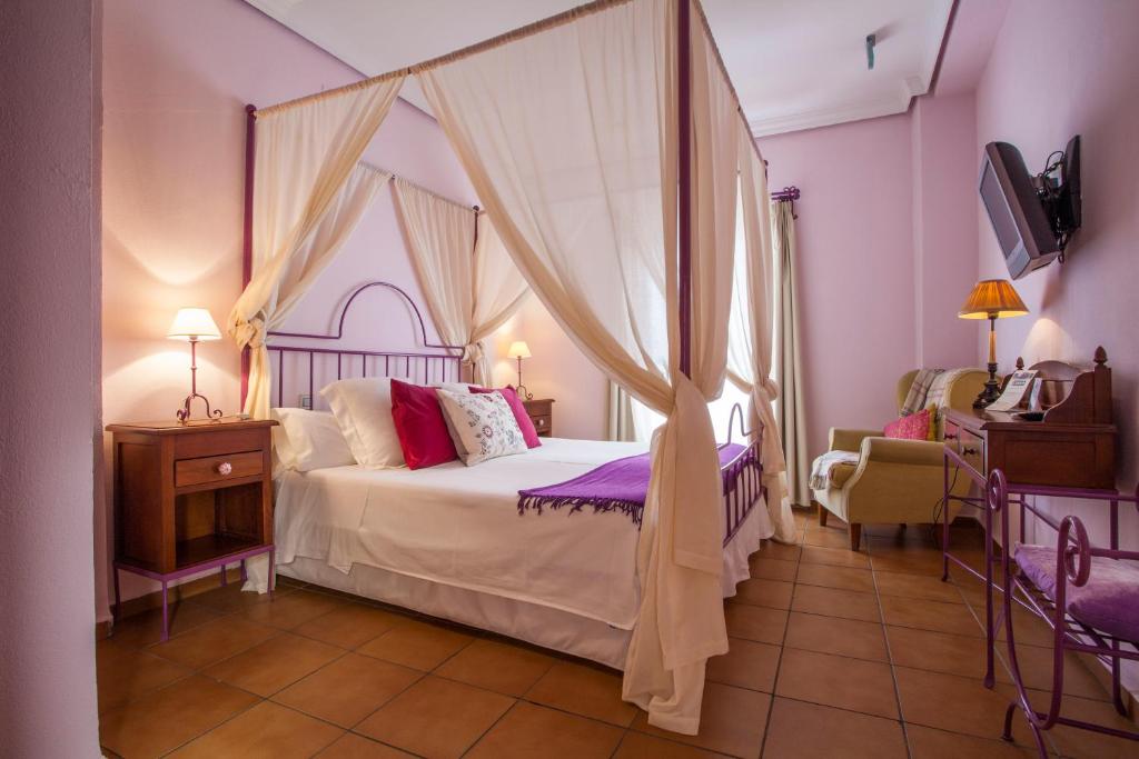 塞维利亚拉卡萨德尔麦艾斯特奥精品酒店的一间卧室配有一张带天蓬的床