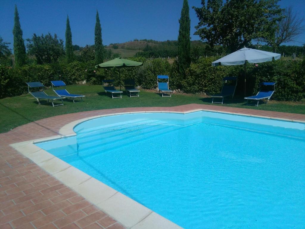 波吉邦西Casa ai Carfini的一个带椅子和遮阳伞的蓝色游泳池