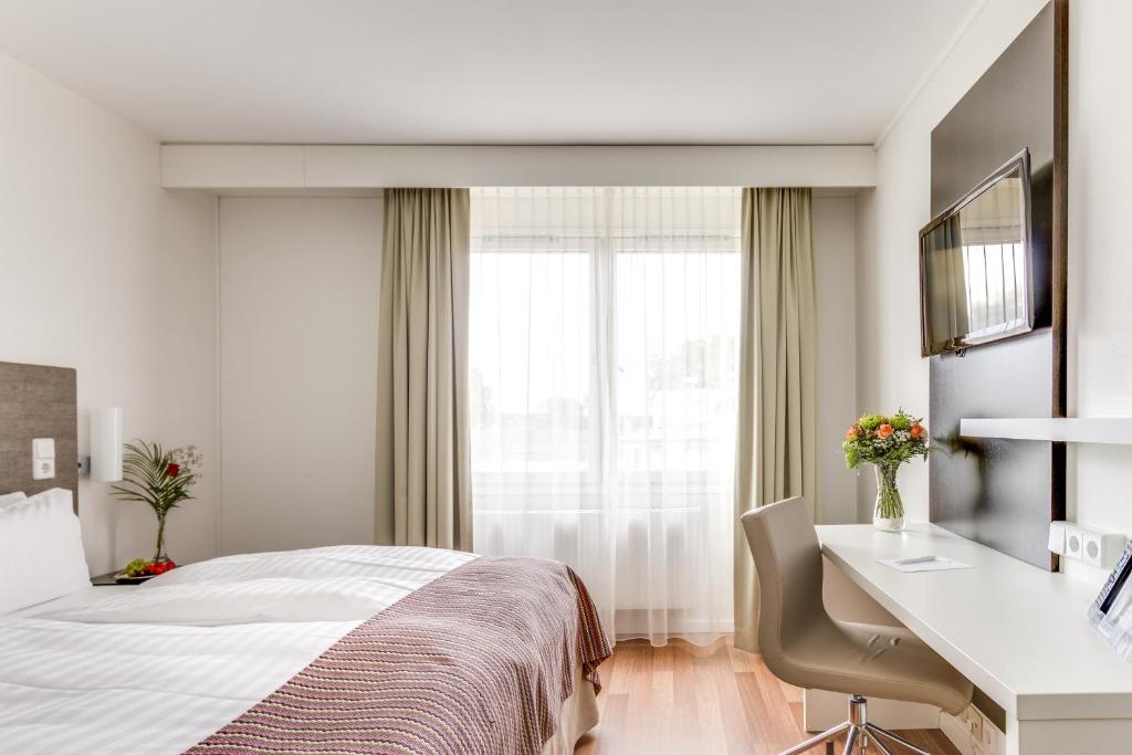 尼雪平早安尼雪平酒店的配有一张床、一张书桌和一扇窗户的酒店客房