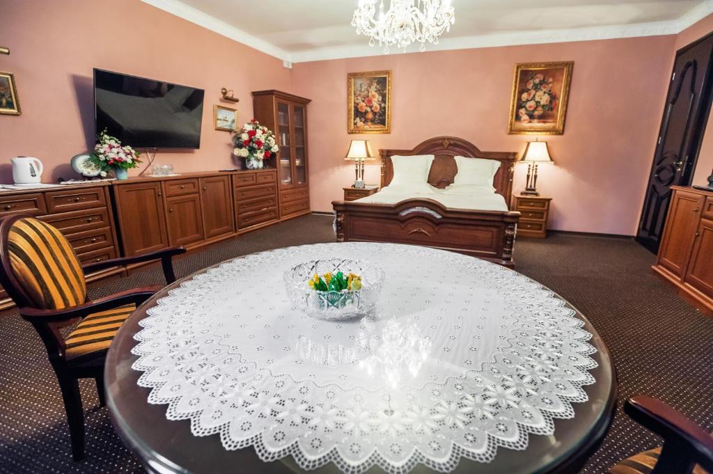 利沃夫Saban Deluxe的客厅配有桌子和床。