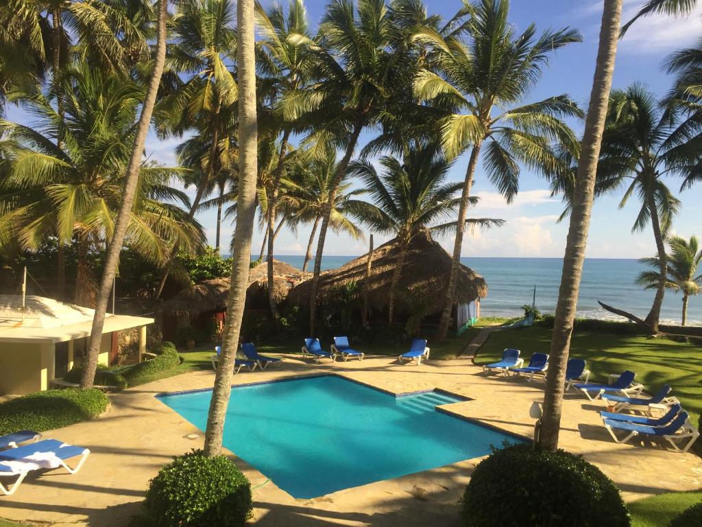 喀巴里特拉蓬塔公寓式酒店的棕榈树和海洋的度假游泳池