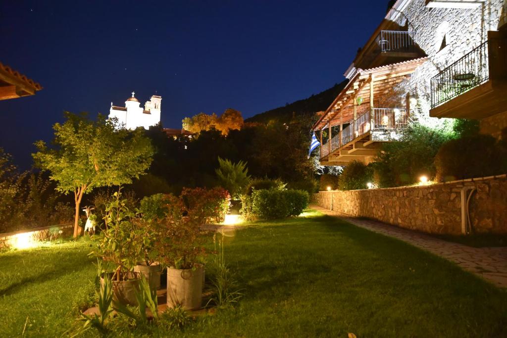 Piána帕帕尼可拉酒店的一座花园,在晚上有城堡背景