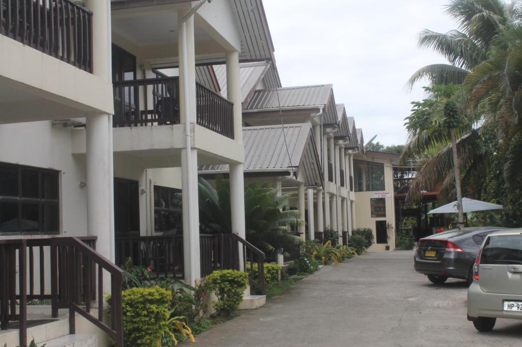 辛加东卡莎丽妮花园公寓酒店的街道上一排有汽车的房屋