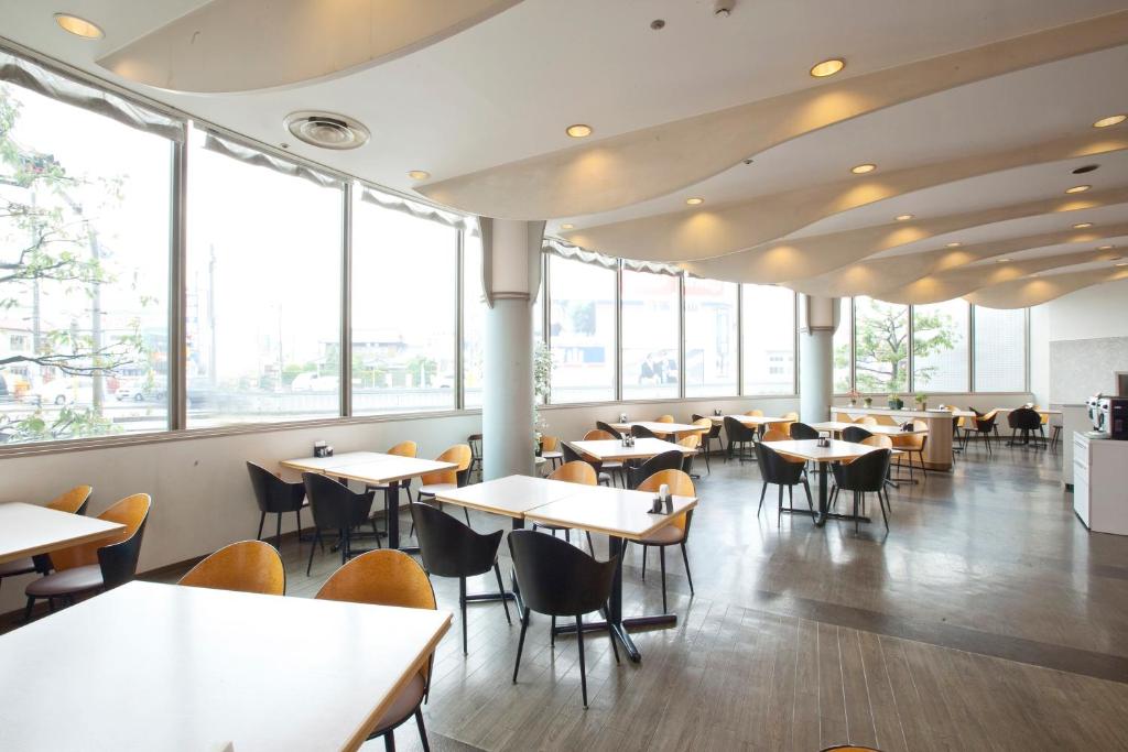 多治见市多治见欧斯塔国际酒店的餐厅设有桌椅和窗户。