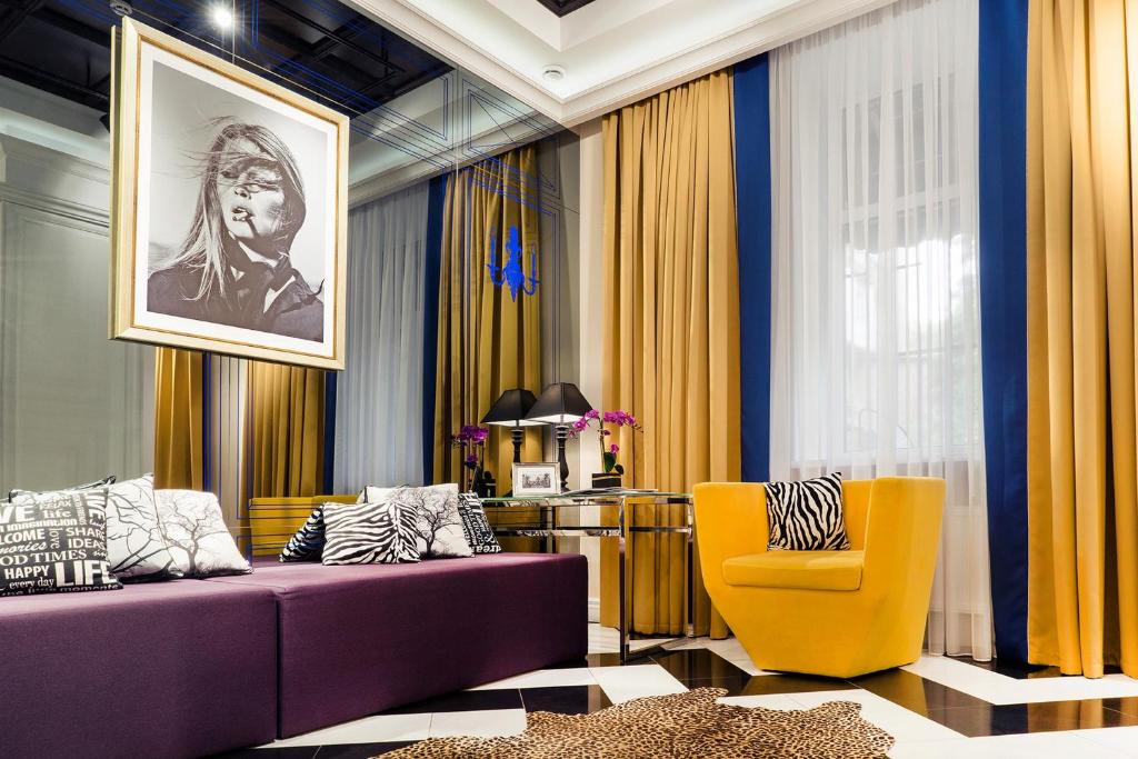 哈尔科夫米拉克斯蓝宝石精品酒店的客厅配有紫色沙发和黄色椅子