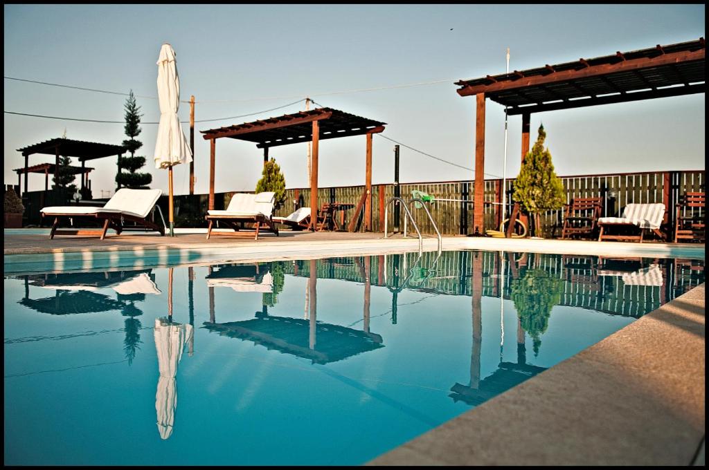 斯卡拉卡伦尼斯ilyda Residence apts的一个带椅子的游泳池和一个凉亭