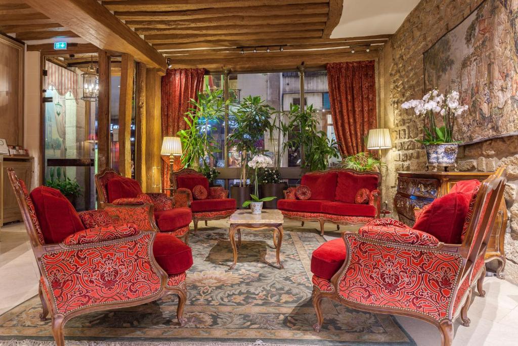 巴黎鲁尼沃圣日耳曼大酒店的客厅配有红色椅子和桌子