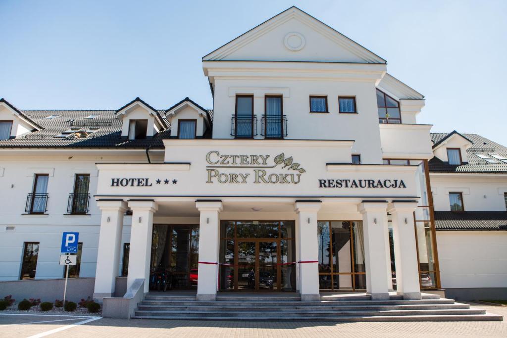 波德拉谢地区别尔斯克Hotel Cztery Pory Roku的白色的建筑,有门廊的排屋