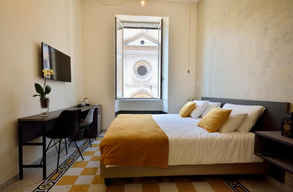 罗马Room with a view 105的一间卧室配有一张床、一张书桌和一个窗户。
