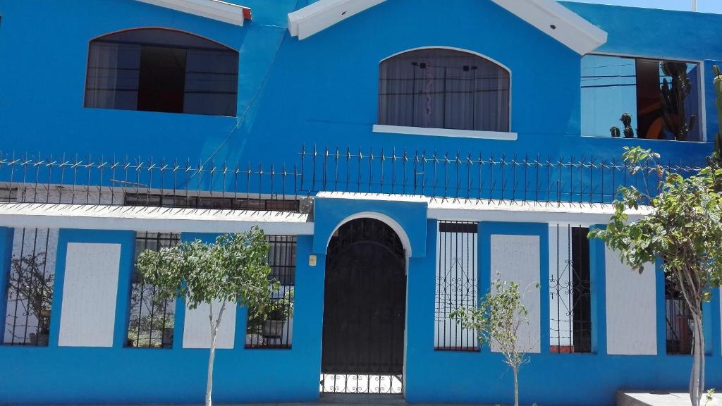阿雷基帕Ramirez House的一座蓝白色的建筑,前面有树木